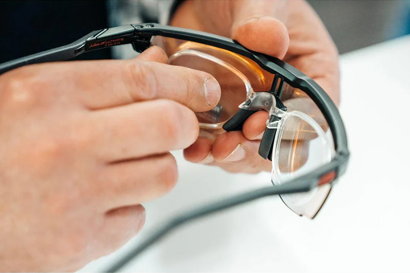 Hands adjusting optical clip on glasses
